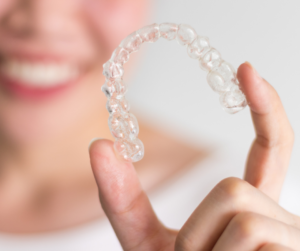 woman holding her Invisalign braces