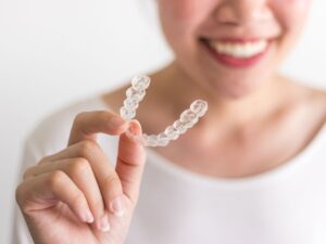 woman holding her Invisalign appliance