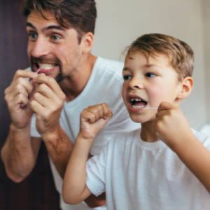 father and son flossing their teeth